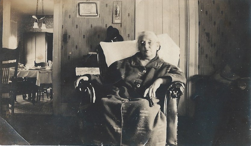 Sarah Porter seated in a chair in a living room.
